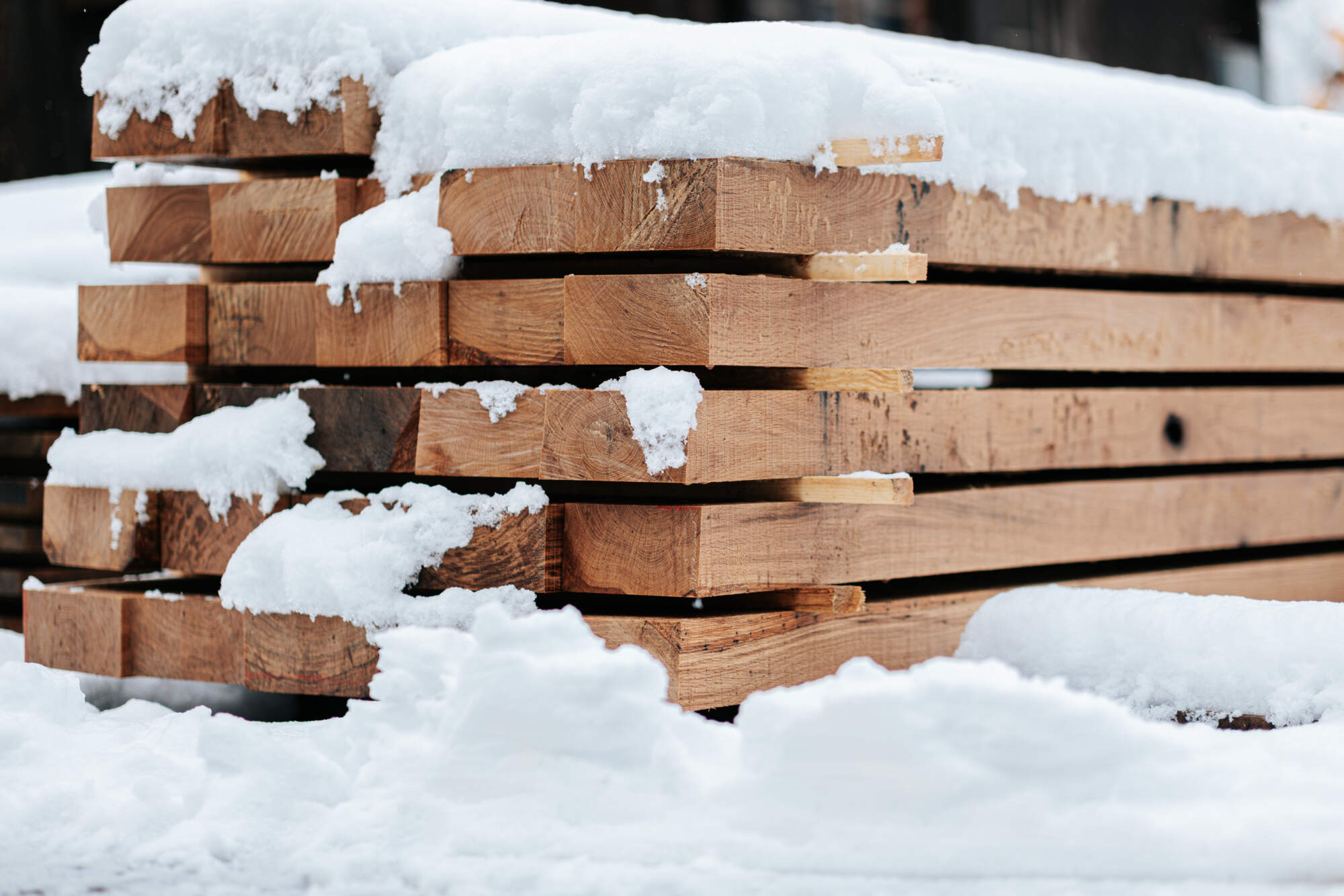 Stock de planches de bois sous la neige